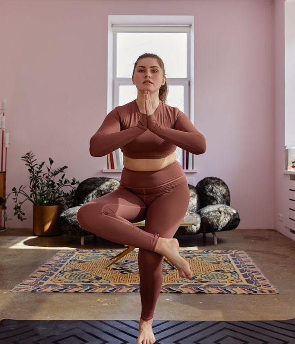 Woman in a calm yoga pose, embodying daily harmony and wellness.